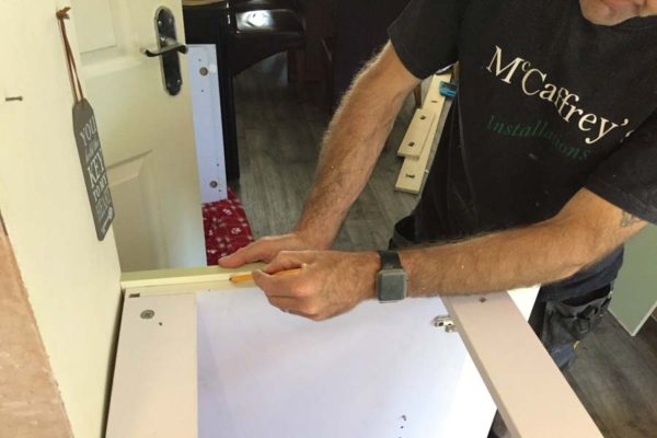 marking up end panel by kitchen fitter in corby